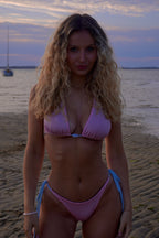 Maillot de bain deux piéce triangle modulable rose avec liens bleu ciel pour femme trois petites perles se trouve au centre de haut.